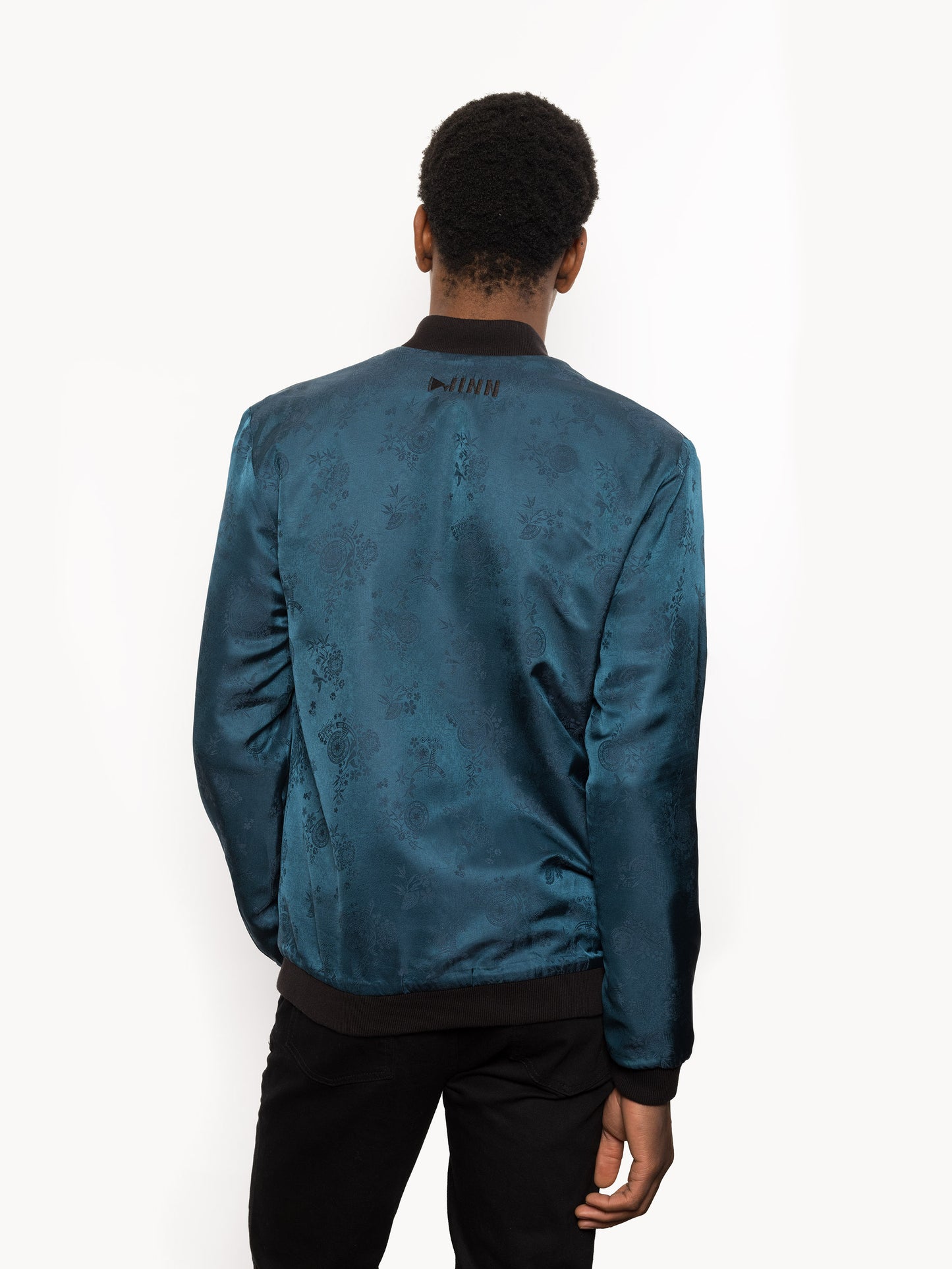 "Introducing Kaelu's exclusive 'DJINN' silk bomber jacket, numbered 1 to 20. Meticulously crafted in Vietnam using authentic Vietnamese silk, this reversible marvel features a refined blend of green and black, exuding subtle classiness. Unlike the bold Japanese sukajan, this piece offers understated luxury with a nod to urban sophistication."