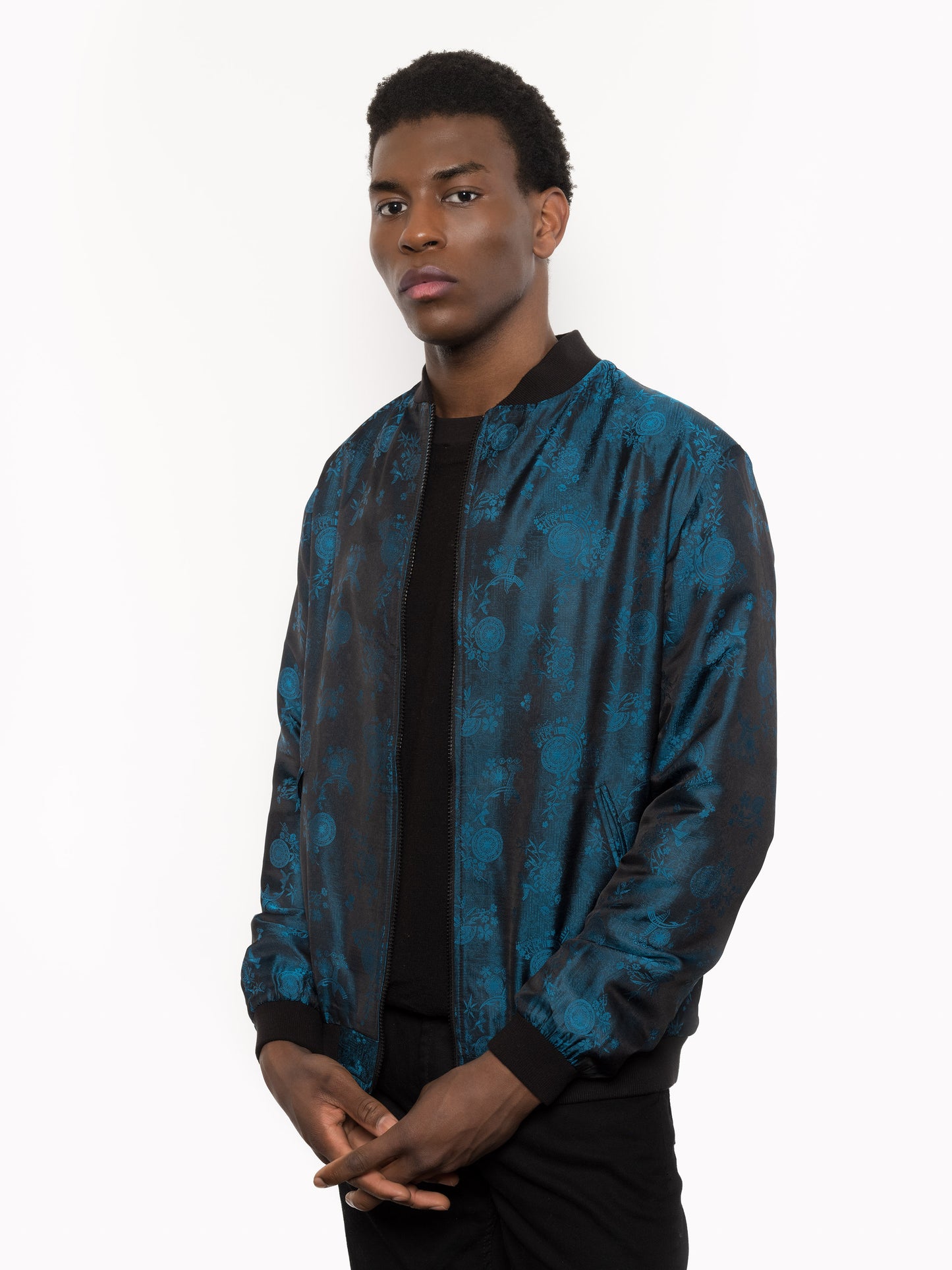 "Kaelu's limited edition 'DJINN' silk bomber jacket, numbered 1 to 20. Handcrafted in Vietnam with authentic Vietnamese silk, this reversible jacket offers versatility with one side in striking blue and the other in sleek black. Combining Asian luxury with urban style, it's fairtrade and fashion-forward, epitomizing streetwear sophistication."