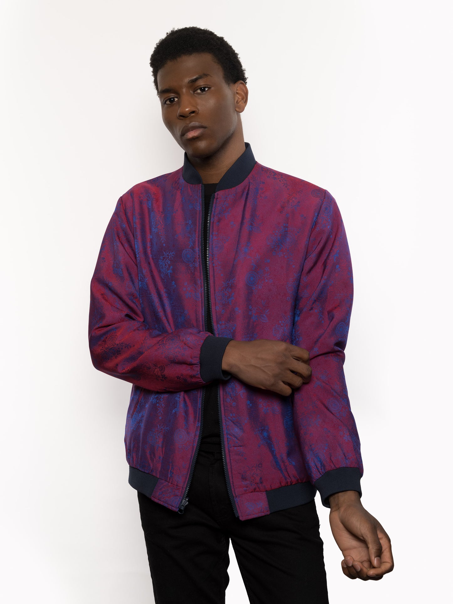"Presenting Kaelu's exclusive 'DJINN' silk bomber jacket, numbered 1 to 20. Handcrafted in Vietnam from authentic Vietnamese silk, this reversible masterpiece offers two distinct hues of purple: one leaning towards a deep blue-purple, the other towards a soft pink-purple, complementing black skin tones impeccably. Embrace understated elegance with this piece, a departure from the vibrant Japanese sukajan, exuding sophistication in every detail."