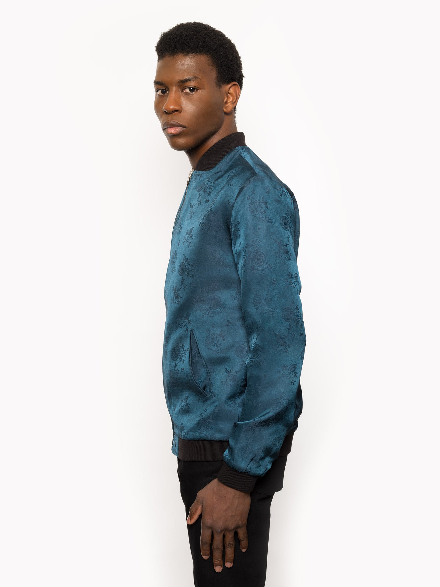 "Introducing Kaelu's exclusive 'DJINN' silk bomber jacket, numbered 1 to 20. Meticulously crafted in Vietnam using authentic Vietnamese silk, this reversible marvel features a refined blend of green and black, exuding subtle classiness. Unlike the bold Japanese sukajan, this piece offers understated luxury with a nod to urban sophistication."