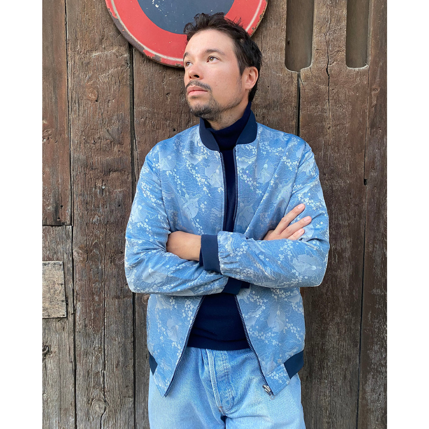 Close-up of Raphaël Hiribarne styling his Kaelu silk bomber jacket with a turtleneck — a chic and modern interpretation of the Kaelu spirit.
