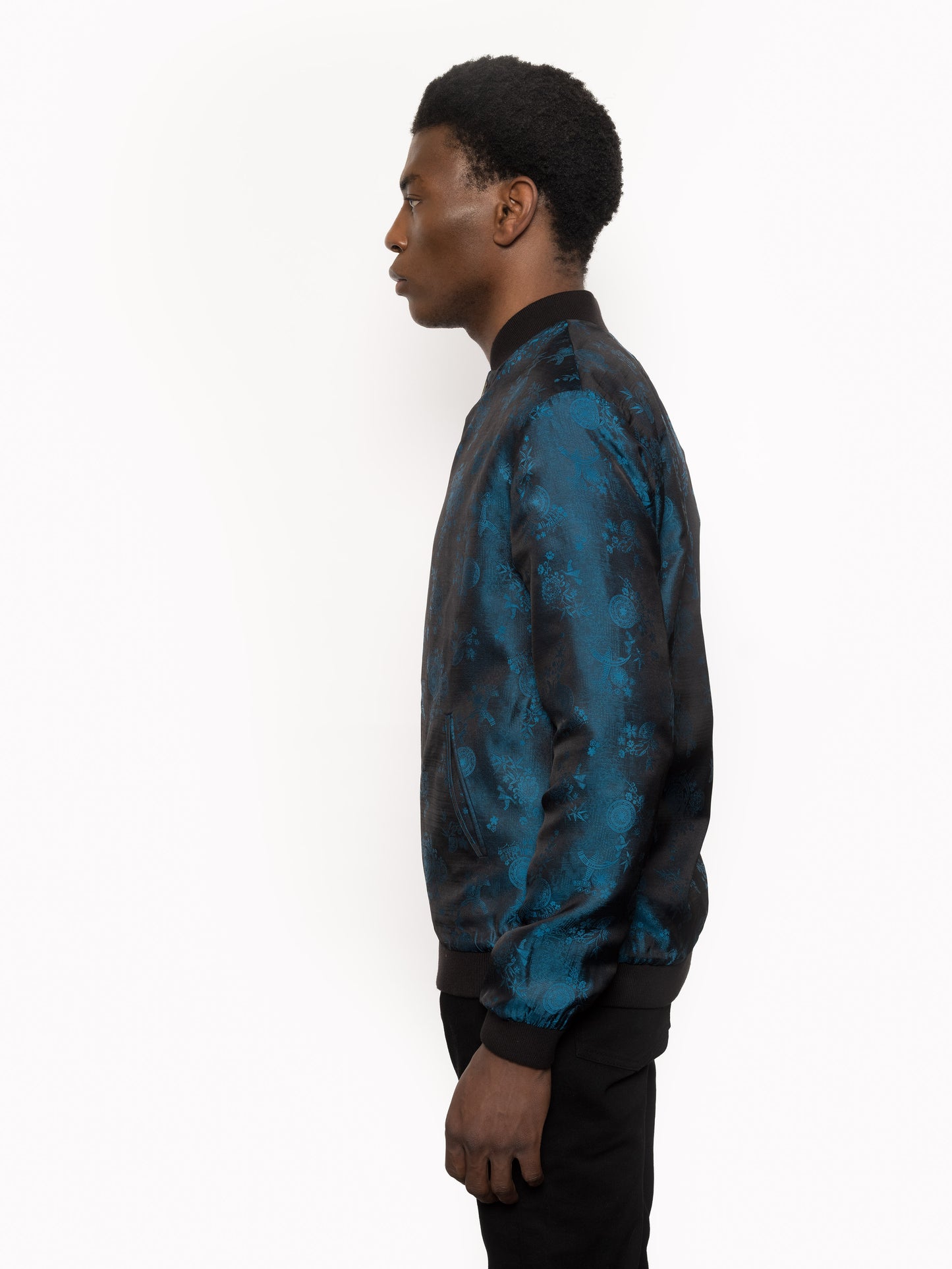 "Kaelu's limited edition 'DJINN' silk bomber jacket, numbered 1 to 20. Handcrafted in Vietnam with authentic Vietnamese silk, this reversible jacket offers versatility with one side in striking blue and the other in sleek black. Combining Asian luxury with urban style, it's fairtrade and fashion-forward, epitomizing streetwear sophistication."