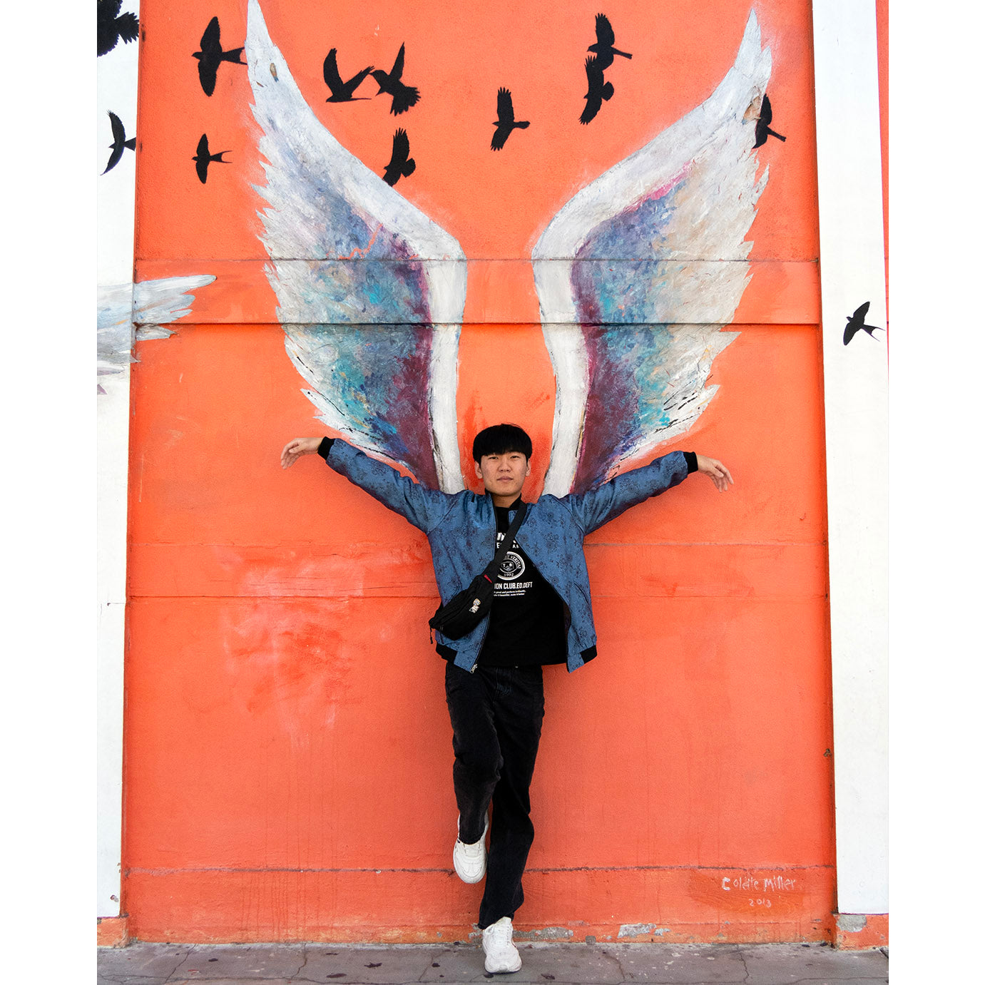 Xeon showing the reversible Kaelu silk bomber jacket — one styled in light grey with black outfit.