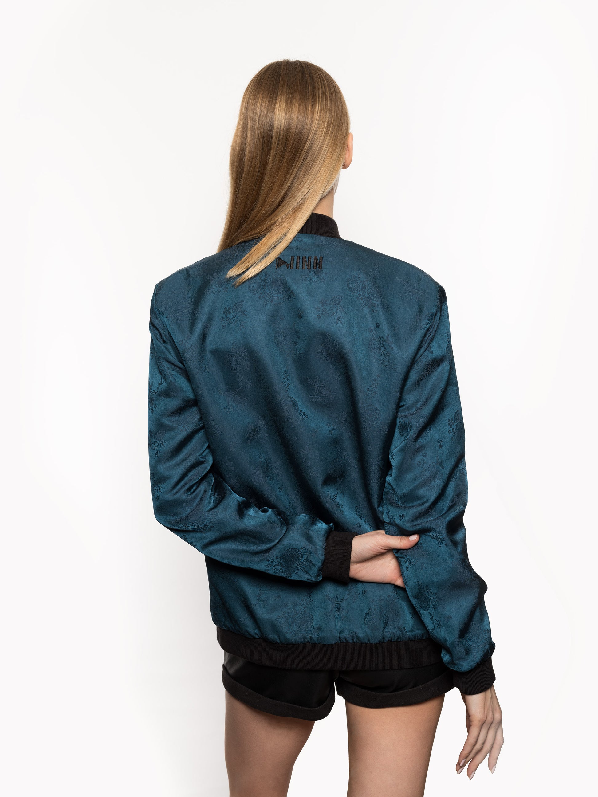 "Introducing Kaelu's exclusive 'DJINN' silk bomber jacket, numbered 1 to 20. Meticulously crafted in Vietnam using authentic Vietnamese silk, this reversible marvel features a refined blend of green and black, exuding subtle classiness. Unlike the bold Japanese sukajan, this piece offers understated luxury with a nod to urban sophistication."