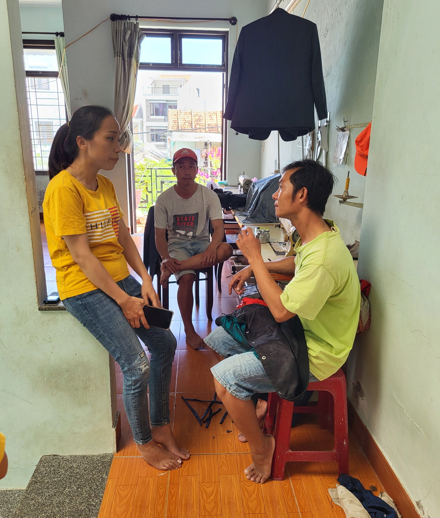 Vietnamese workers talking about crafting a silk bomber jacket