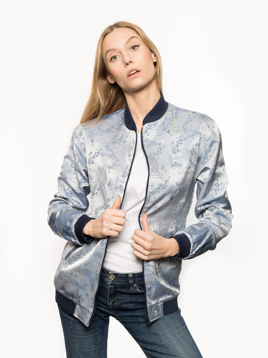 "Introducing Kaelu's exclusive 'DJINN' silk bomber jacket, numbered 1 to 20. Handcrafted in Vietnam with authentic Vietnamese silk, this reversible wonder showcases a stunning combination of silver and blue, adorned with graceful heron bird and mount fuji motifs. A true standout piece, offering a departure from the traditional, it's a symbol of sophistication and urban flair."