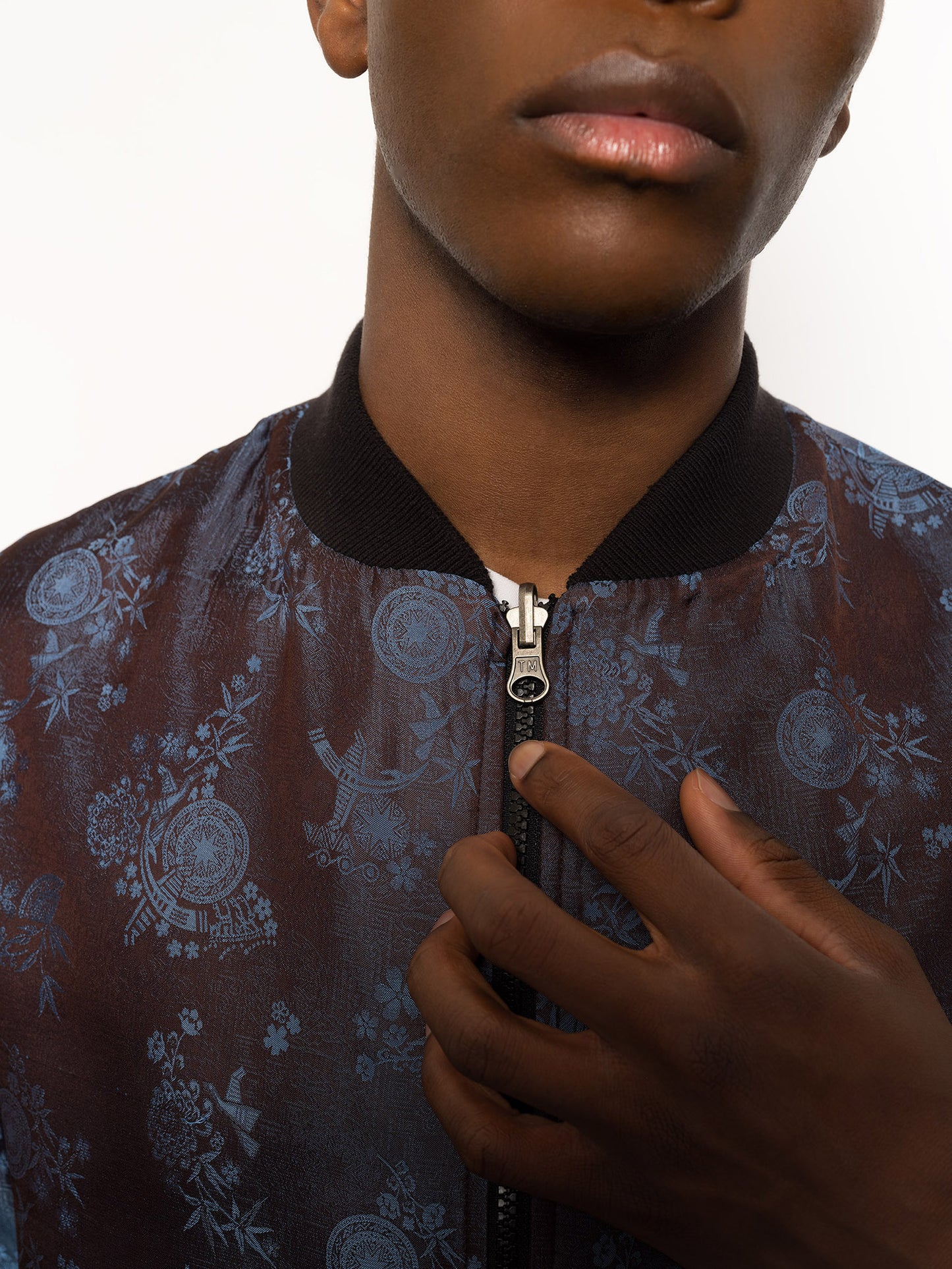 "Kaelu's limited edition 'DJINN' silk bomber jacket, numbered 1 to 20. Handcrafted in Vietnam with authentic Vietnamese silk, this reversible jacket offers versatility with one side in dark gray and the other in blue gray. Combining Asian luxury with urban style, it's fairtrade and fashion-forward, epitomizing streetwear sophistication."