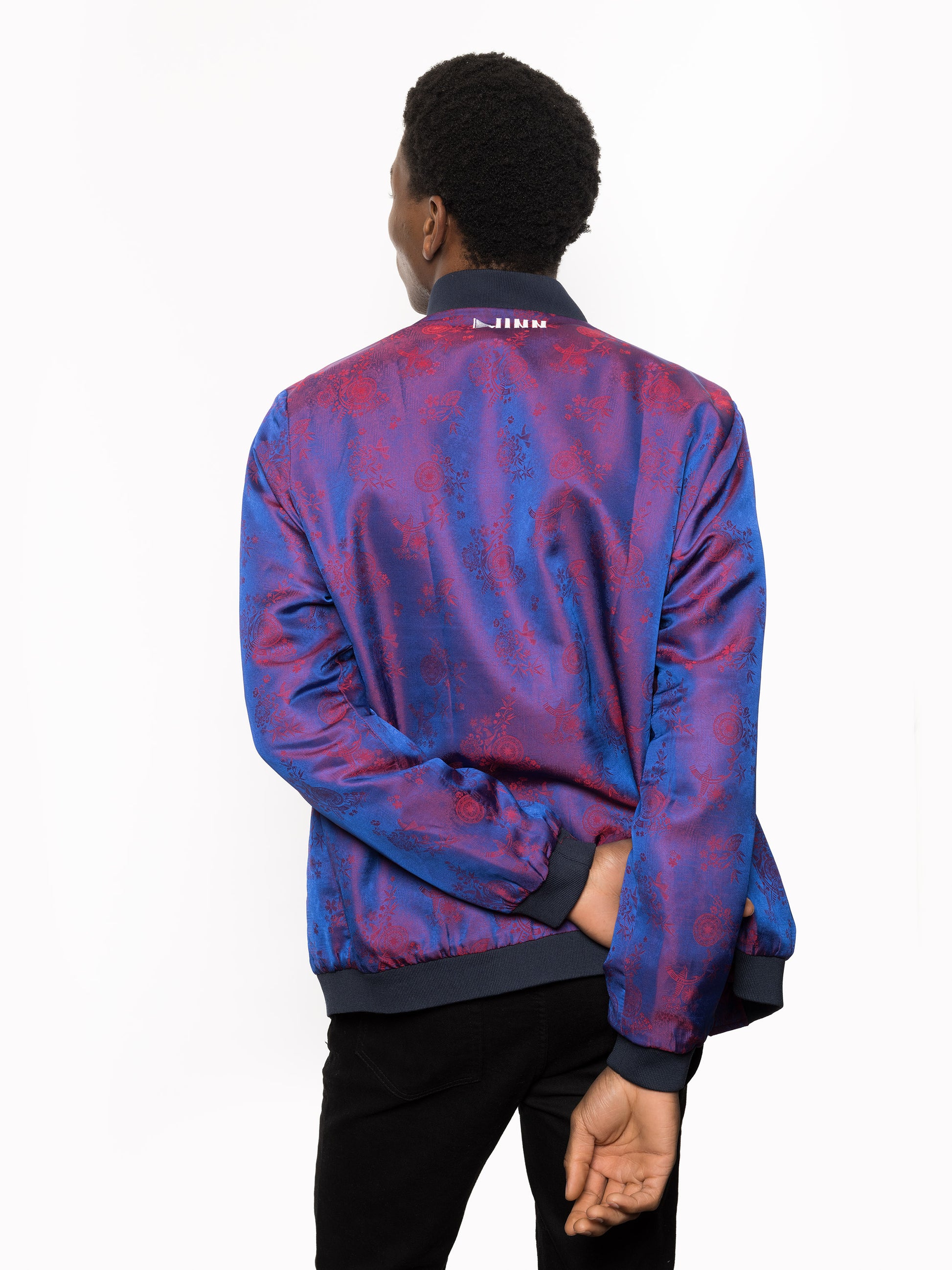 "Presenting Kaelu's exclusive 'DJINN' silk bomber jacket, numbered 1 to 20. Handcrafted in Vietnam from authentic Vietnamese silk, this reversible masterpiece offers two distinct hues of purple: one leaning towards a deep blue-purple, the other towards a soft pink-purple, complementing black skin tones impeccably. Embrace understated elegance with this piece, a departure from the vibrant Japanese sukajan, exuding sophistication in every detail."