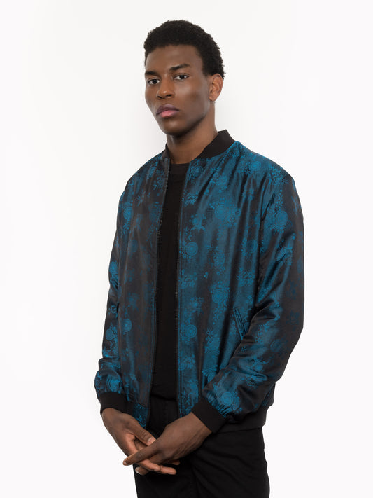 "Kaelu's limited edition 'DJINN' silk bomber jacket, numbered 1 to 20. Handcrafted in Vietnam with authentic Vietnamese silk, this reversible jacket offers versatility with one side in striking blue and the other in sleek black. Combining Asian luxury with urban style, it's fairtrade and fashion-forward, epitomizing streetwear sophistication."