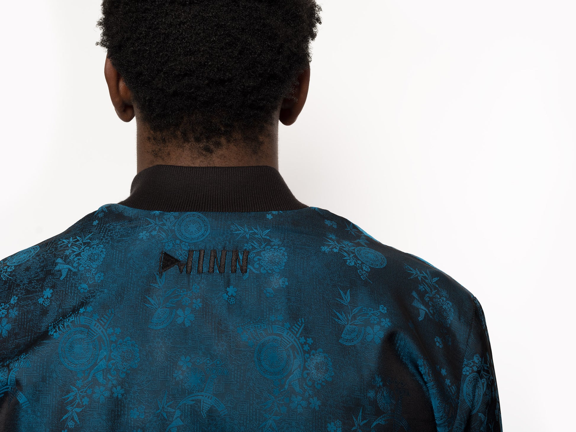"Kaelu's limited edition 'DJINN' silk bomber jacket, numbered 1 to 20. Handcrafted in Vietnam with authentic Vietnamese silk, this reversible jacket offers versatility with one side in striking blue and the other in sleek black. Combining Asian luxury with urban style, it's fairtrade and fashion-forward, epitomizing streetwear sophistication."