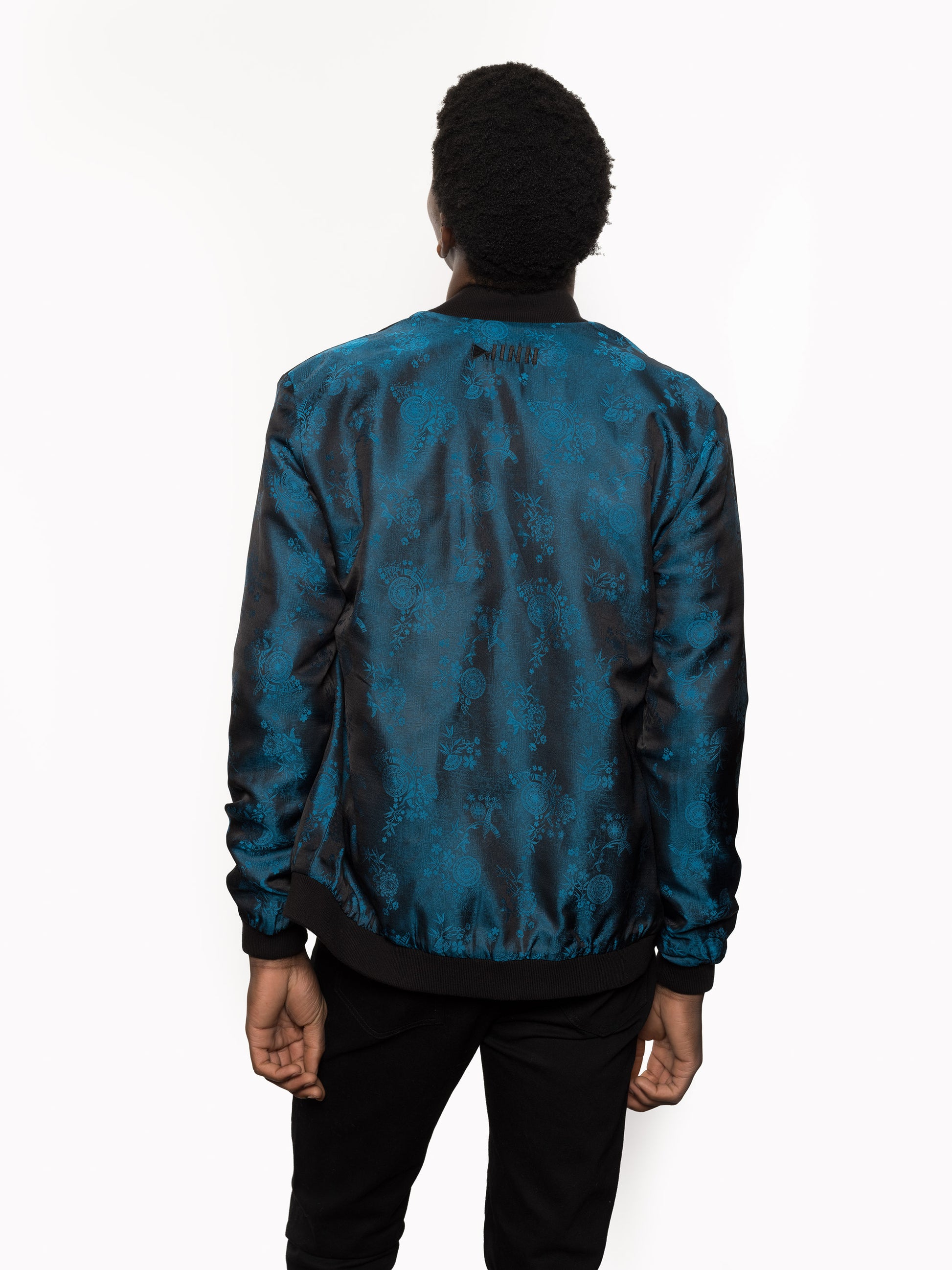 "Kaelu's limited edition 'DJINN' silk bomber jacket, numbered 1 to 20. Handcrafted in Vietnam with authentic Vietnamese silk, this reversible jacket offers versatility with one side in striking blue and the other in sleek black. Combining Asian luxury with urban style, it's fairtrade and fashion-forward, epitomizing streetwear sophistication."