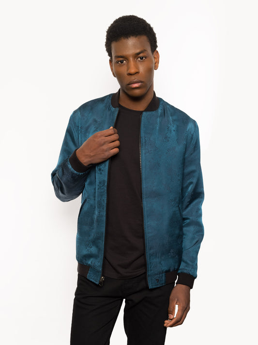 "Introducing Kaelu's exclusive 'DJINN' silk bomber jacket, numbered 1 to 20. Meticulously crafted in Vietnam using authentic Vietnamese silk, this reversible marvel features a refined blend of green and black, exuding subtle classiness. Unlike the bold Japanese sukajan, this piece offers understated luxury with a nod to urban sophistication."