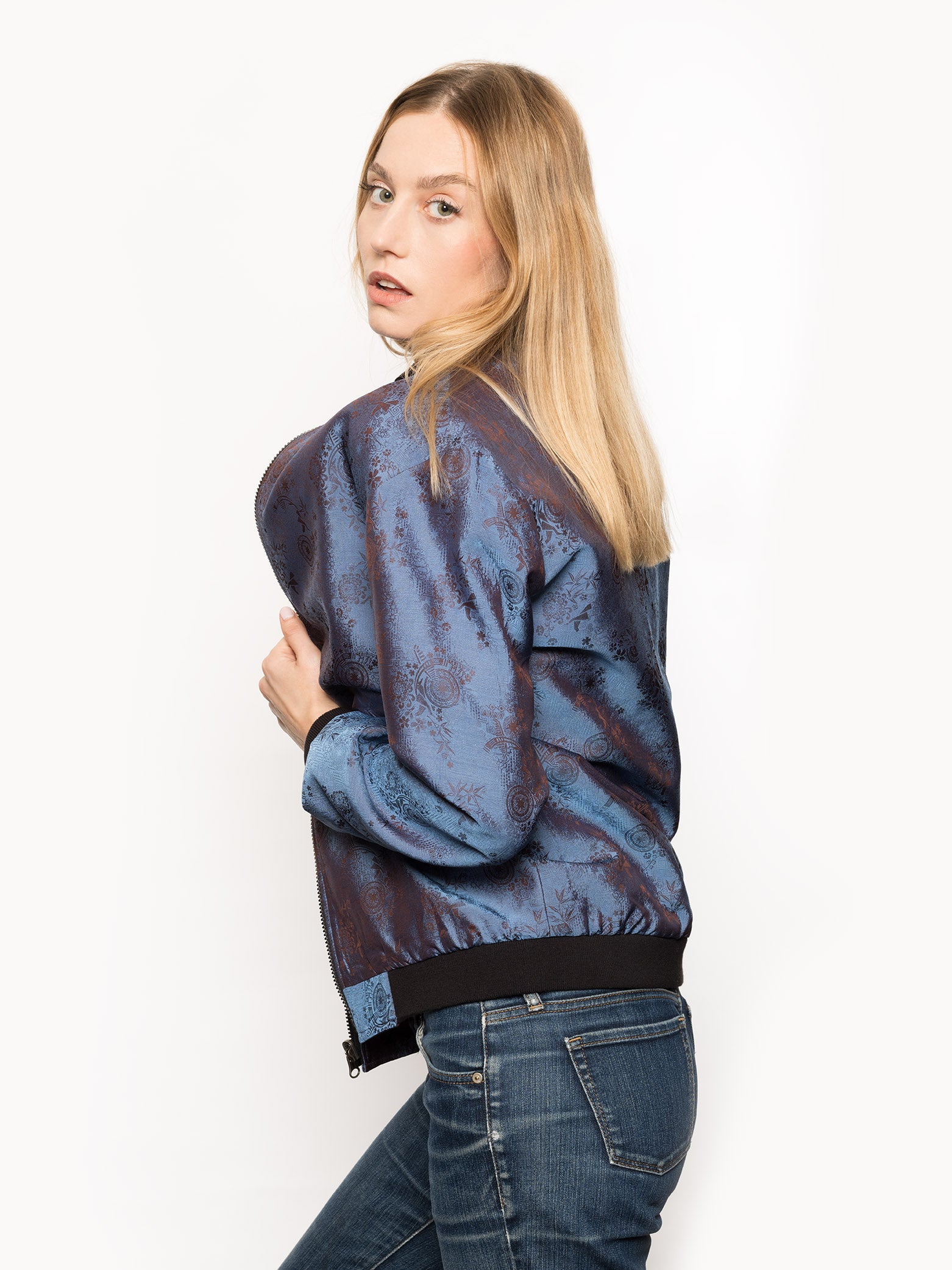 "Kaelu's limited edition 'DJINN' silk bomber jacket, numbered 1 to 20. Handcrafted in Vietnam with authentic Vietnamese silk, this reversible jacket offers versatility with one side in dark gray and the other in blue gray. Combining Asian luxury with urban style, it's fairtrade and fashion-forward, epitomizing streetwear sophistication."