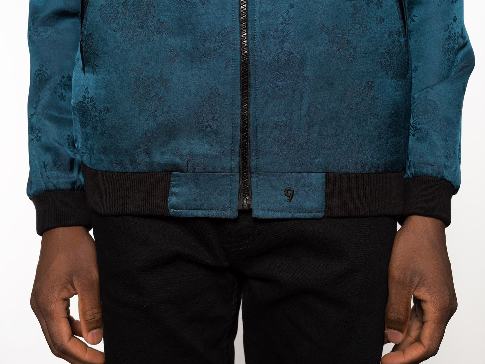 "Introducing Kaelu's exclusive 'DJINN' silk bomber jacket, numbered 1 to 20. Meticulously crafted in Vietnam using authentic Vietnamese silk, this reversible marvel features a refined blend of green and black, exuding subtle classiness. Unlike the bold Japanese sukajan, this piece offers understated luxury with a nod to urban sophistication."