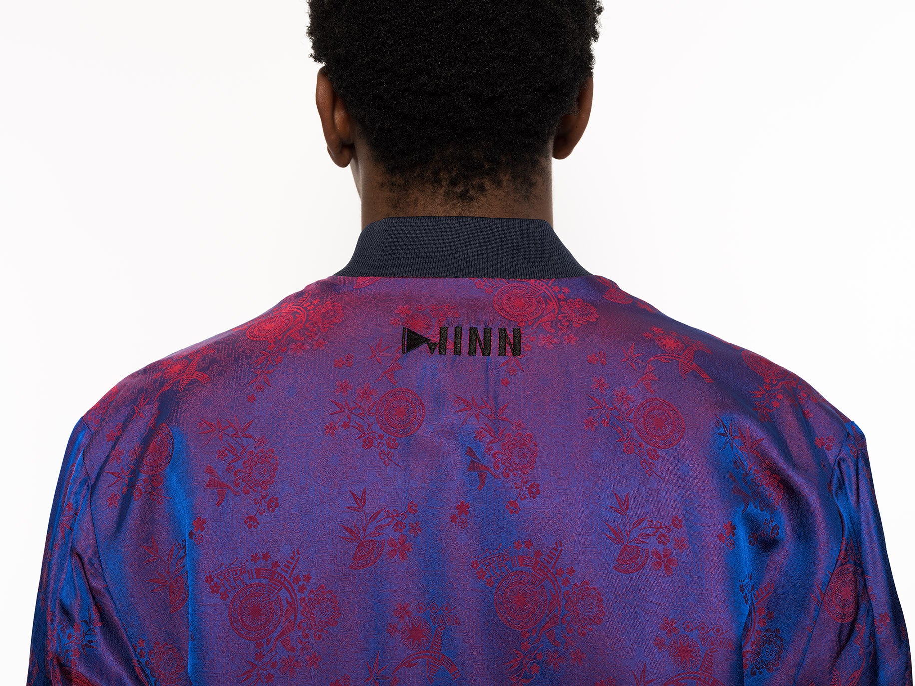 "Presenting Kaelu's exclusive 'DJINN' silk bomber jacket, numbered 1 to 20. Handcrafted in Vietnam from authentic Vietnamese silk, this reversible masterpiece offers two distinct hues of purple: one leaning towards a deep blue-purple, the other towards a soft pink-purple, complementing black skin tones impeccably. Embrace understated elegance with this piece, a departure from the vibrant Japanese sukajan, exuding sophistication in every detail."